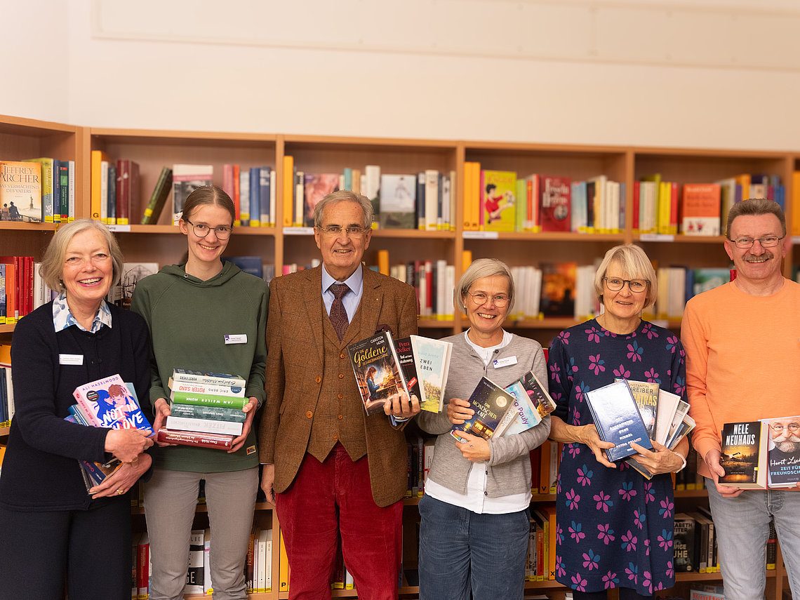 Glücklich über die großzügige Bücherspende: v.l.: Tamina Klein-Ridder, Anne Frevert (beide ehrenamtliche Mitarbeitende der Krankenhausbibliothek), Dr. Joachim Hulde (ehemaliger Chefarzt der Klinik für Frauenheilkunde und Geburtshilfe am Klinikum Gütersloh und Mitglied des Lions Club Gütersloh Teutoburger Wald), Katja Plock (Ehrenamtsbeauftragte im Klinikum Gütersloh), Heidrun Pape und Frank Nötzig (ebenfalls beide ehrenamtliche Mitarbeitende der Krankenhausbibliothek).